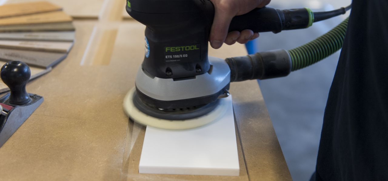 Een close-up van het schuren van een Corian®-plaat uitgevoerd met een Festool schuurmachine.